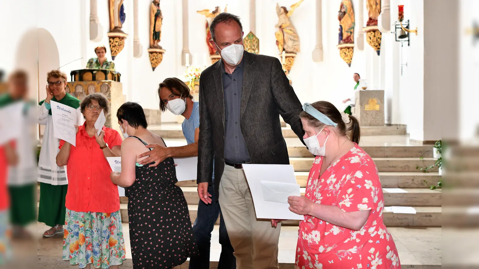 Geschäftsführer Markus Holl (Mitte) übergibt den stolzen Jubilaren ihre Ehrenurkunden. (Foto: Franziskuswerk / Pfab)