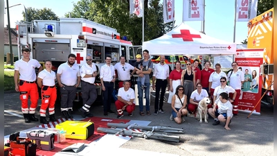 Filialleiter Ricardo Baumgartner (Mitte), umringt von den Rotkreuzlern und Wasserrettungshund Fuchur. (Foto: BRK Dachau)