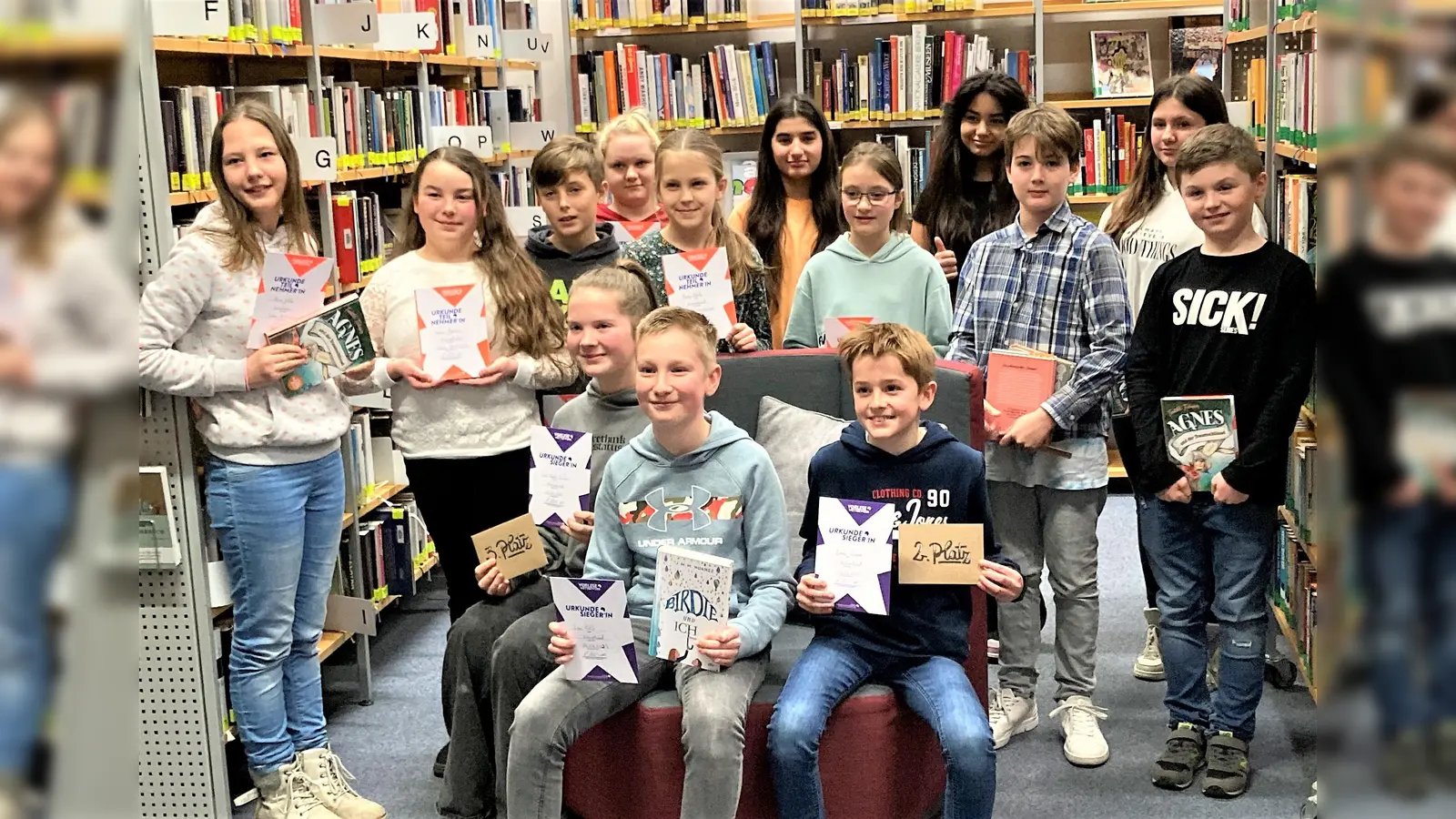 Sieger und Teilnehmer am Kreisentscheid: Leni-Sophie Eichler (li), Sieger Leo Futh und Simon Limmer (re) vorne auf dem Lesesessel. (Foto: Stadtbücherei Dachau)