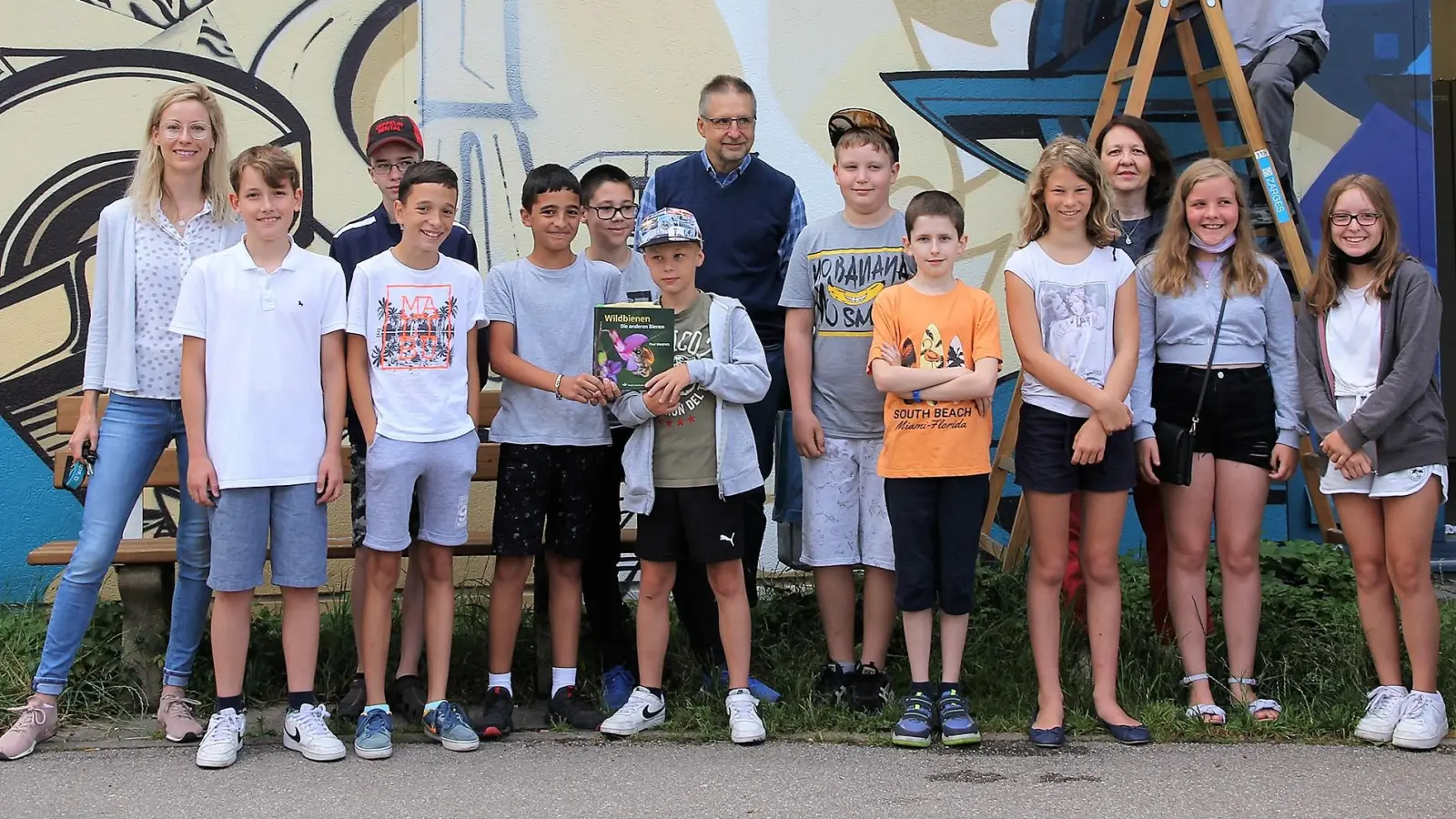 Insektenhotel von Kindern der Mittelschule Dachau-Süd an der Trafostation am Gröbenbach. Mit Hartmut Lichti (hinten Mitte), flankiert von der Klassenlehrerin (li) und Mitarbeitenden der Stadtwerke.<br> (Foto: Stadtwerke Dachau)