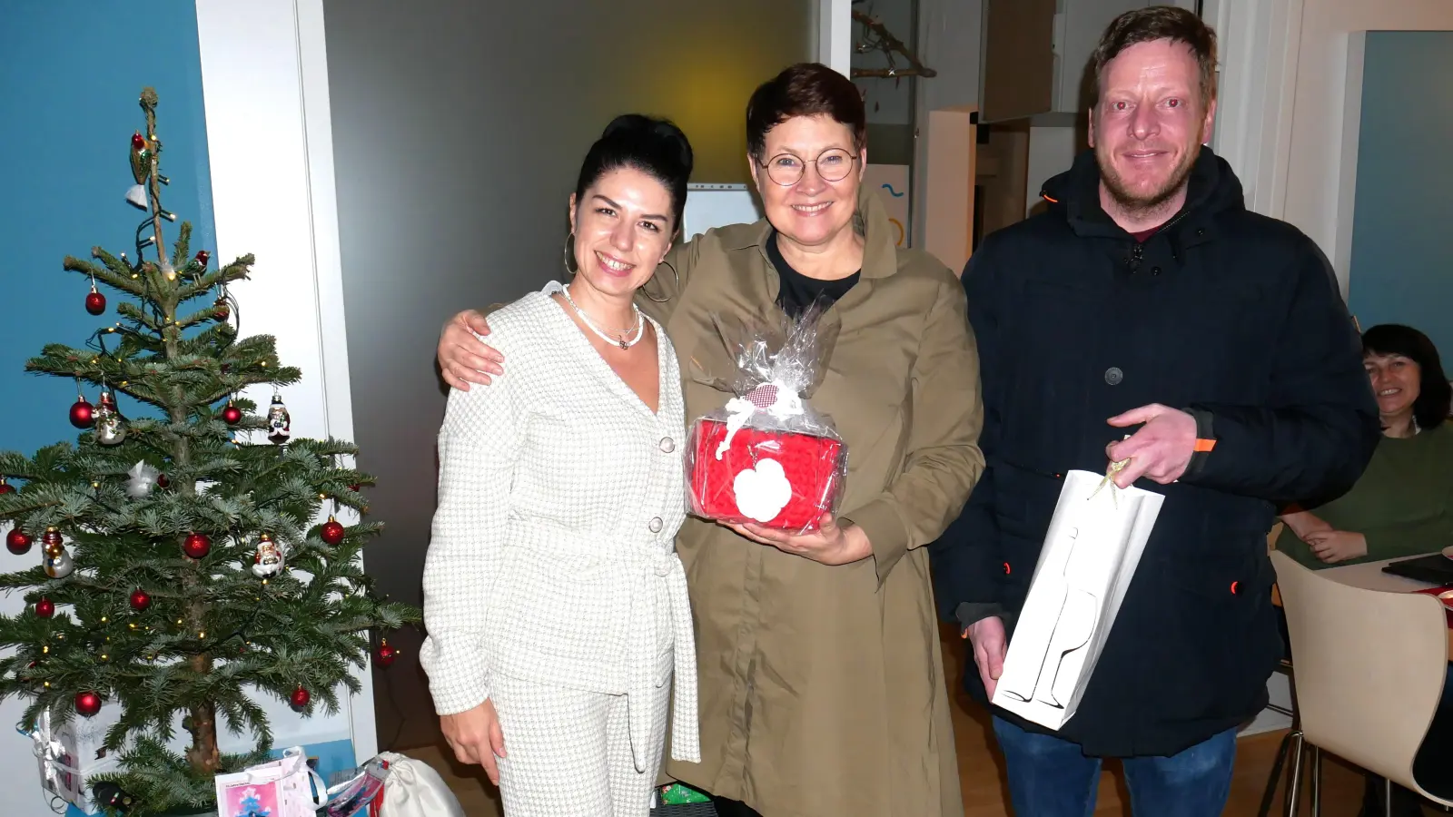 Isabel Seeber (mi) freut sich über eine selbstgehäkelte Tasche von Asia Lunina aus der Ukraine, Marco Reichlmayr über ein gutes Tröpfchen. (Foto: MGH Dachau)