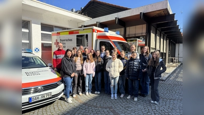 Bernhard Seidenath (l.), stellvertretende Personalleiterin Diana Tielman (2. v. l.), Dennis Behrendt (hinten Mitte) mit den Schülerinnen am im BRK. (Foto: BRK - Kreisverband Dachau)
