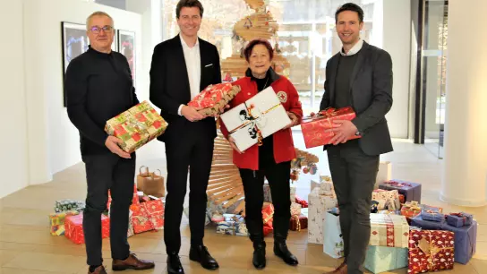 Andreas Kraut, Klaus Berger und Florian Rohrmüller (von li) überreichen Edda Drittenpreis die Weihnachtsgeschenke in der VR-Hauptstelle. (Foto: VR Bank)
