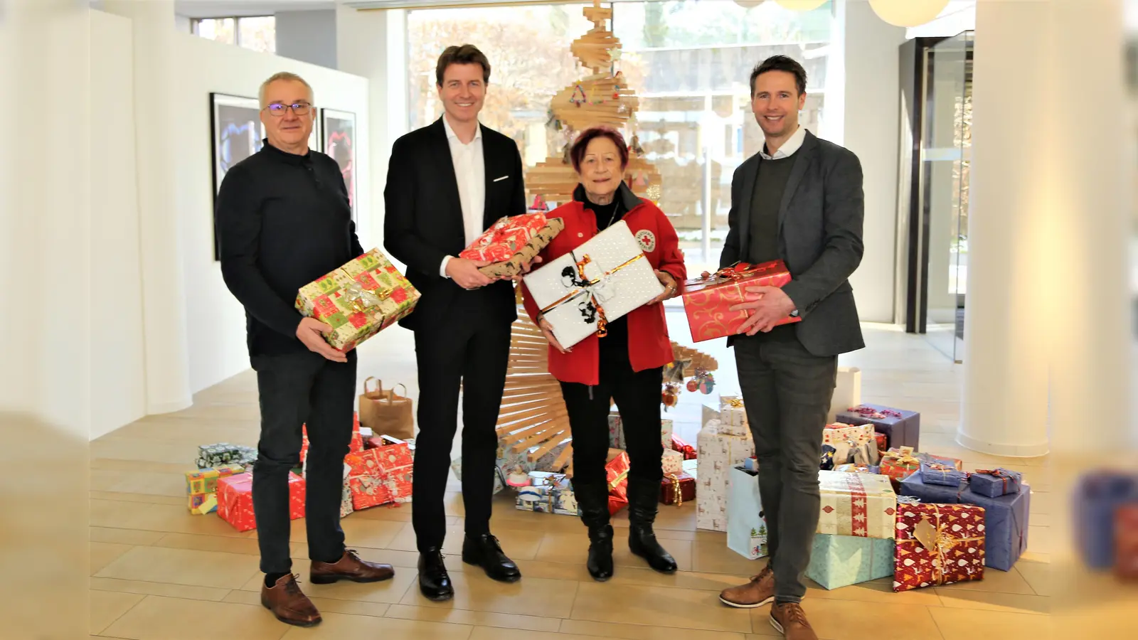 Andreas Kraut, Klaus Berger und Florian Rohrmüller (von li) überreichen Edda Drittenpreis die Weihnachtsgeschenke in der VR-Hauptstelle. (Foto: VR Bank)