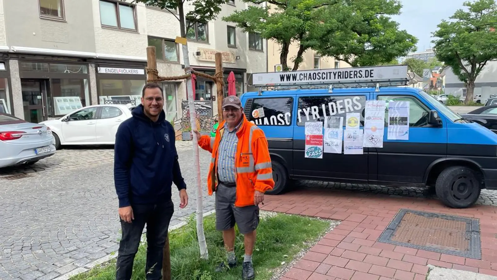 Frank Großhans (re) vom Stadtgrün mit Chaoscityrider-Vorsitzendem Bernard Zeidler und dem neuen Baum in der Augsburgerstraße. (Foto: Chaoscityriders)
