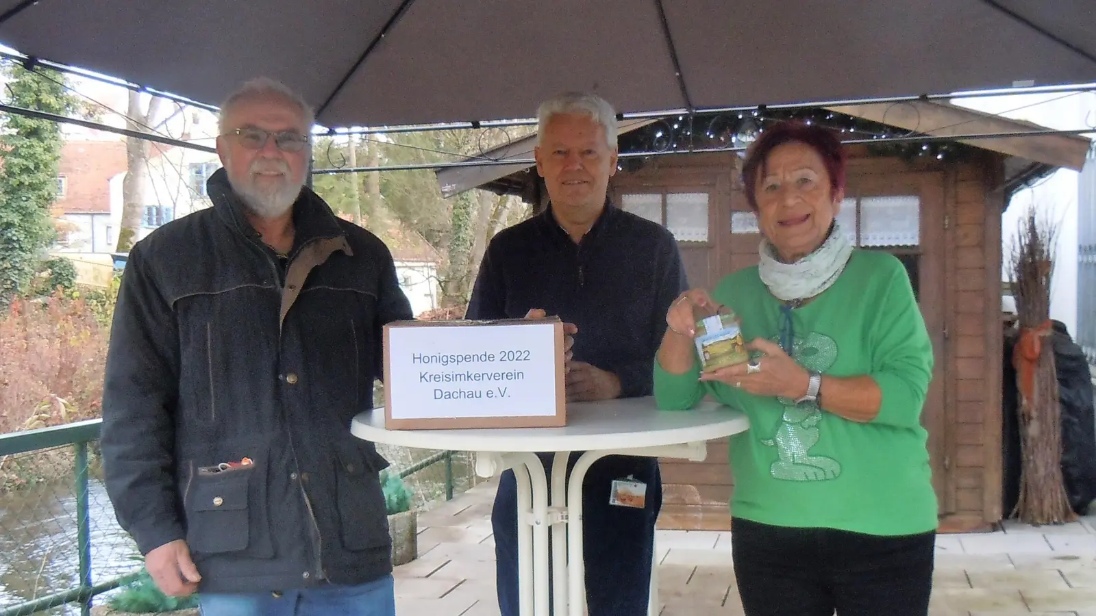 Walter Niedermeier (li) übergibt den Honig an Albert Solleder und Edda Drittenpreis. (Foto: BRK Dachau)