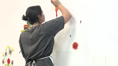 Schülerpraktikantin Marlene malt ein Wandbild im neuen Aufenthaltsraum der Tagesstätte „ProBe“ im Caritas-Zentrum Dachau (Foto: Caritas)