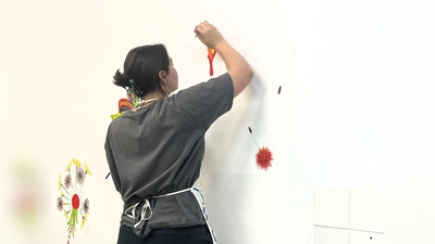 Schülerpraktikantin Marlene malt ein Wandbild im neuen Aufenthaltsraum der Tagesstätte „ProBe“ im Caritas-Zentrum Dachau (Foto: Caritas)