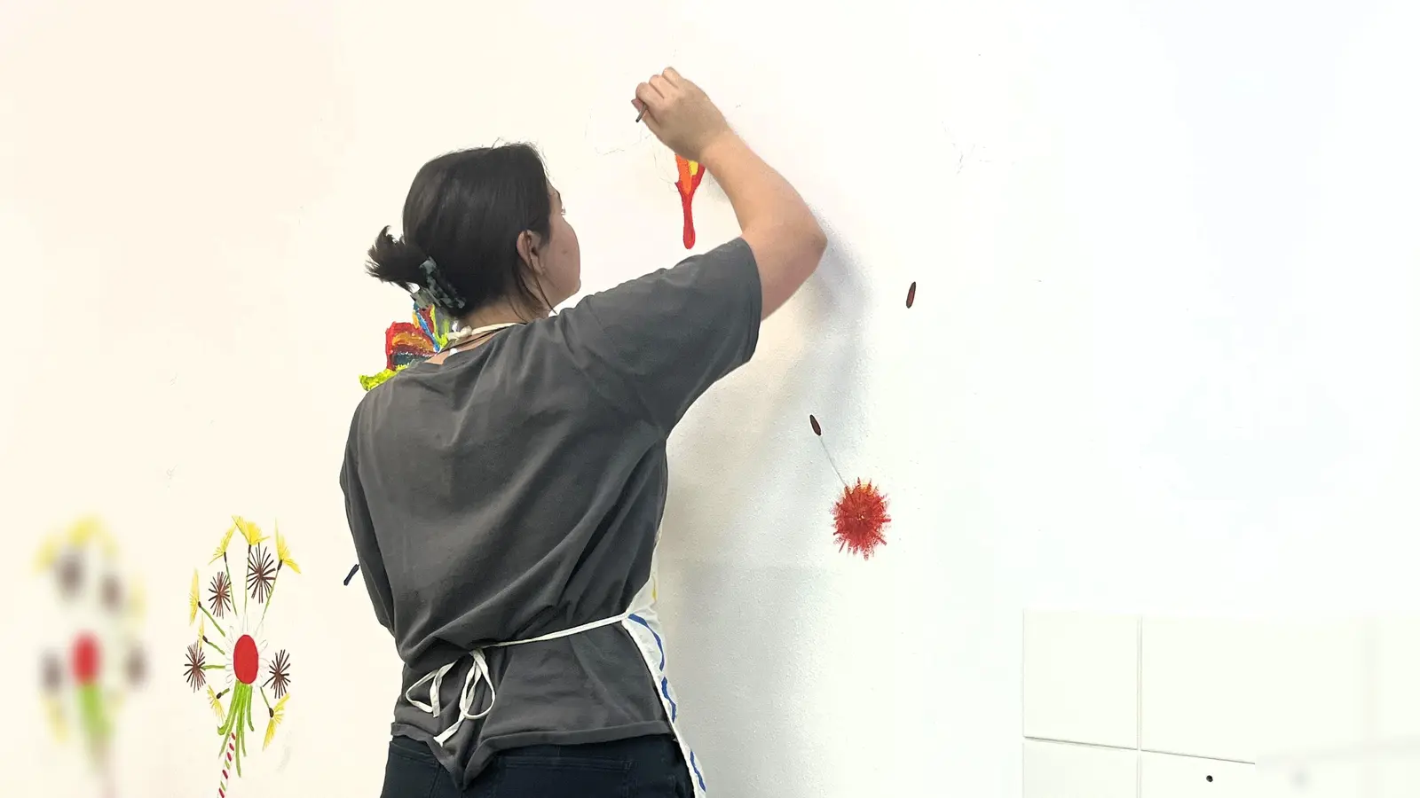 Schülerpraktikantin Marlene malt ein Wandbild im neuen Aufenthaltsraum der Tagesstätte „ProBe“ im Caritas-Zentrum Dachau (Foto: Caritas)