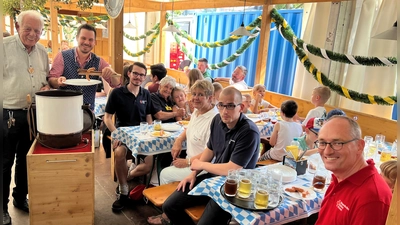 Rudi Stauss mit Service-Kraft Manuel, Dennis Behrendt, Betreuerin Gudrun Boer, Angelika Gumowski, Stefan Tezner und Bernhard Seidenath (von li) am Tisch mit den Kindern. (Foto: BRK Dachau)