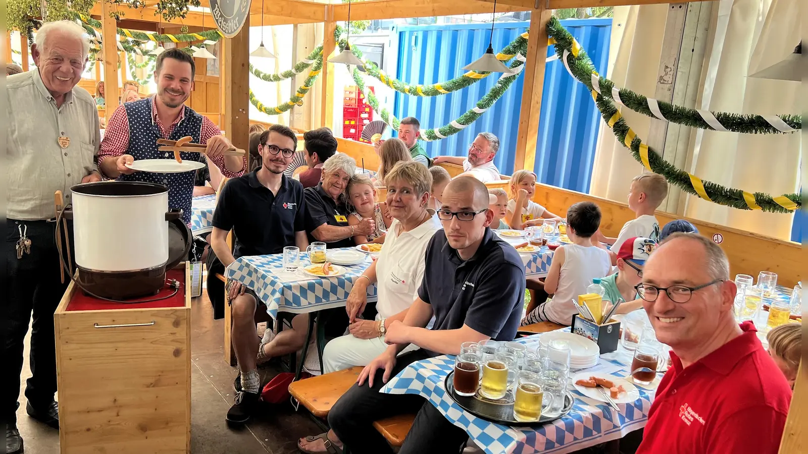 Rudi Stauss mit Service-Kraft Manuel, Dennis Behrendt, Betreuerin Gudrun Boer, Angelika Gumowski, Stefan Tezner und Bernhard Seidenath (von li) am Tisch mit den Kindern. (Foto: BRK Dachau)