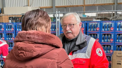  Hans Ramsteiner nimmt einen Karton mit gespendeter Winterkleidung entgegen. (Foto: BRK Dachau)