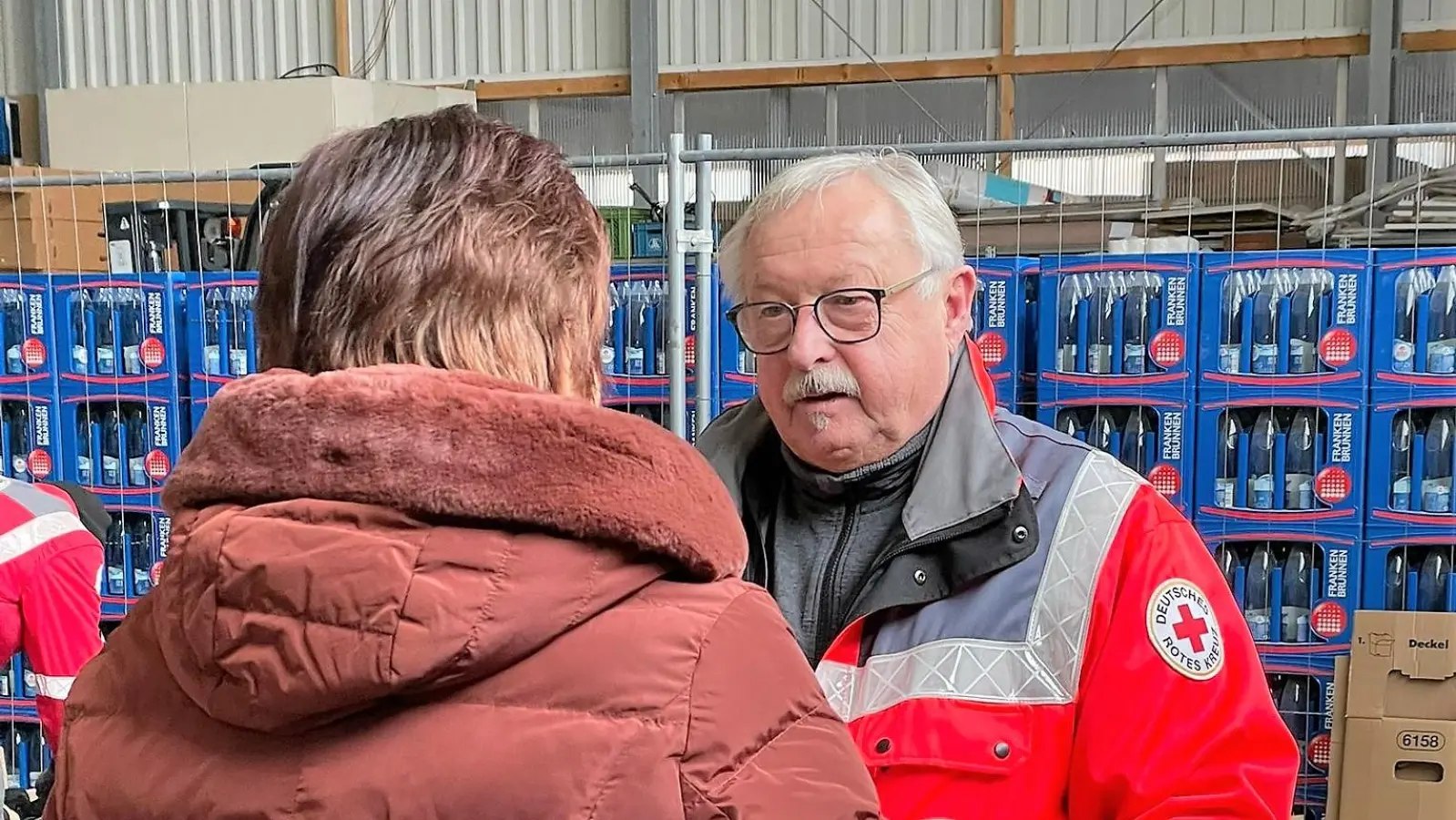  Hans Ramsteiner nimmt einen Karton mit gespendeter Winterkleidung entgegen. (Foto: BRK Dachau)