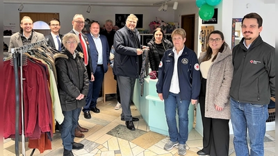 Landrat Stefan Löwl (Mitte) kaufte sich bei Assunta Osterauer (hinter der Theke) am Eröffnungstag gleich zwei Krawatten. (Foto: BRK Dachau)