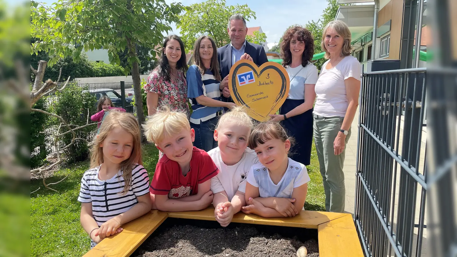 Nina, Edgar, Amelie und Emma vor dem neuen Hochbeet mit ihren Erzieherinnen, Bürgermeister Johannes Kneidl und Michaela Steiner (2. von re). (Foto: VR-Bank Dachau)