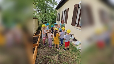 Gemeinsames Bepflanzen der neuen Gemüsebeete mit Frau Anders, Vorsitzende des Gartenbauvereins. (Foto: Kindergarten Wirbelwind)