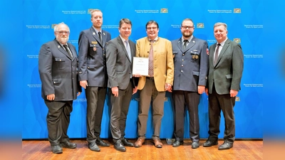 Ehrung mit (von li) Klaus Thalhofer, Kreisbrandinspektor Kasimir Solms-Baruth, Innenstaatssekretär Sandro Kirchner, Maierbräu-Geschäftsführer Christoph Maier, stv. Kommandant Josef Schweighart und der Bayerische Staatsminister für Wohnen, Bau und Verkehr Christian Bernreiter. (Foto: Sebastian Widmann / StMI)