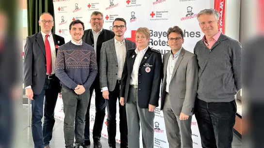 Tizian Bartling (2. vonli) stellt seine Arbeit vor: Bernhard Seidenath, Stefan Löwl, Dennis Behrendt, Angelika Gumowski, Florian Hartmann und Albert Knoll (von li). (Foto: BRK Dachau)