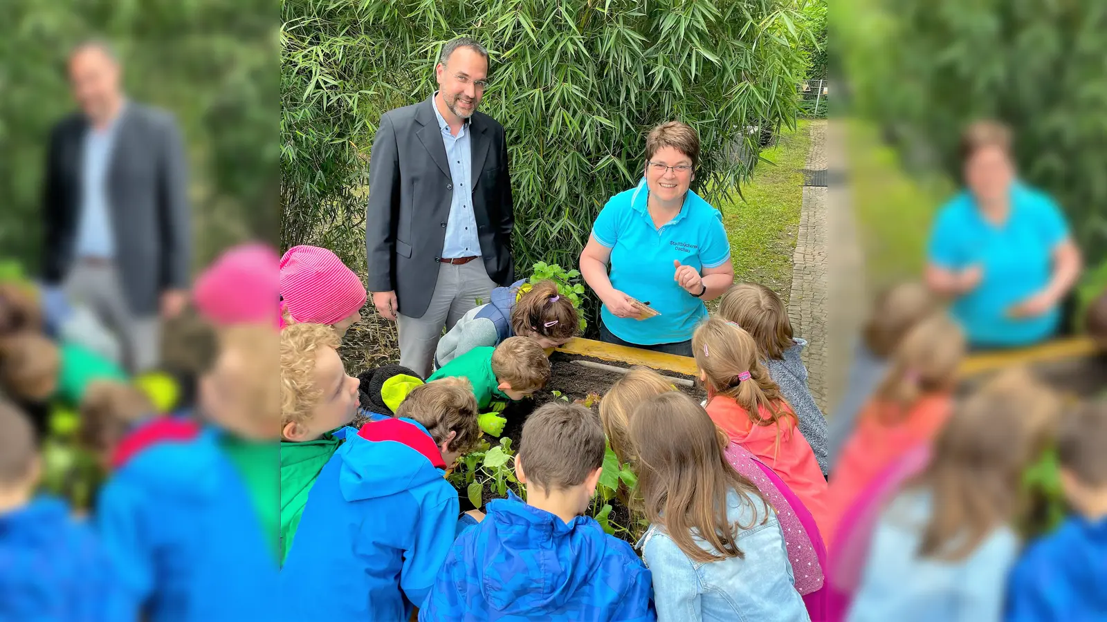 Ulrich Zeiler, VR Bank Dachau, und Birgitt Heermann mit den Kindern am Hochbeet. (Foto: VR-Bank)