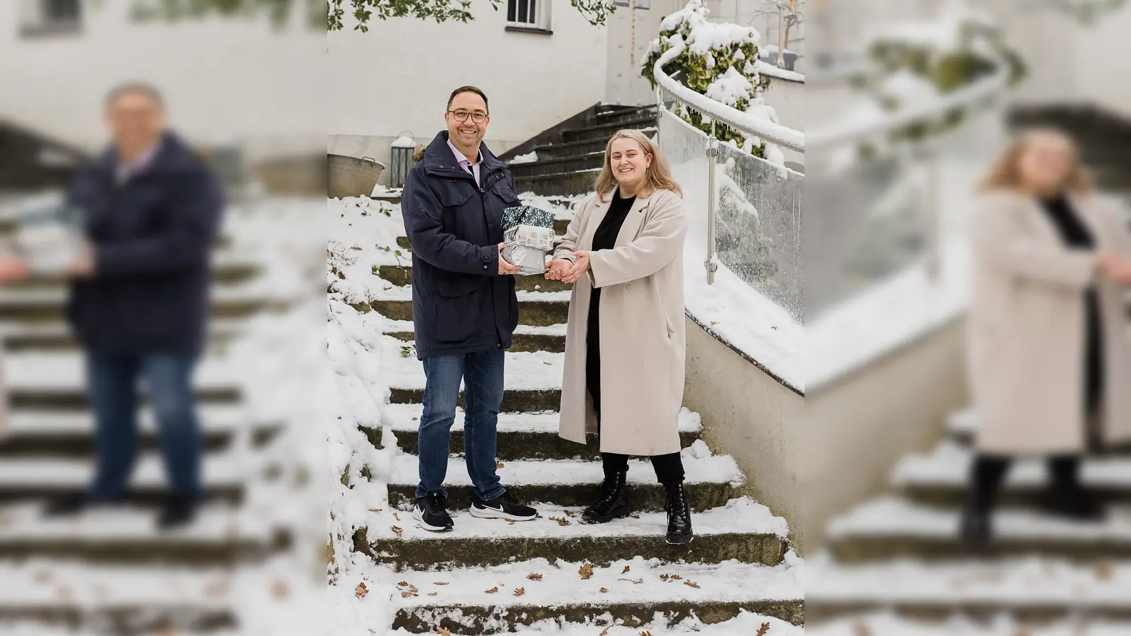 Ulf Tausche, Vorsitzender des Montessori Vereins Dachau, übergab die Weihnachtsgeschenke im Hof des Kinderhauses an Laura Kaufmann, Leiterin des AWO-Frauenhauses in Dachau. (Foto: red)