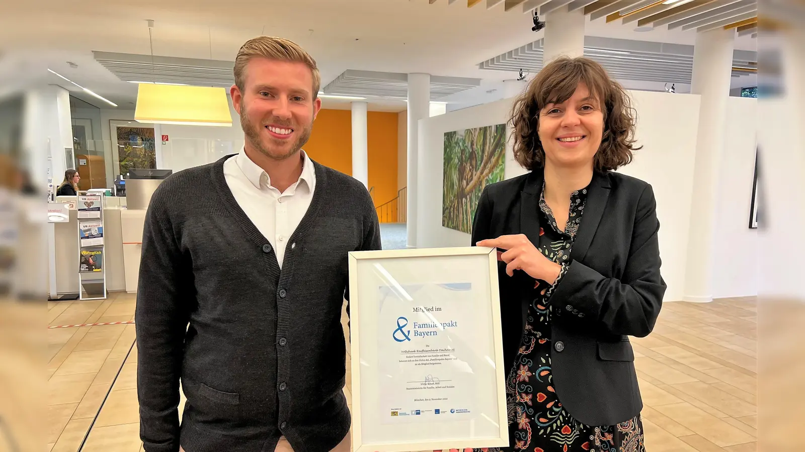 Die Leiterin Unternehmensentwicklung Eva Marie Meuter und Employer-Brand-Manager René Alexander Kaiser mit der Urkunde des Familienpakts Bayern. (Foto: VR Bank Dachau)