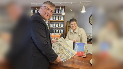 Landrat Stefan Löwl und Isabel Seeber, Vorstand Dachau Handelt, freuen sich über das neue Stickeralbum. (Foto: LRA Dachau, Sina Török)
