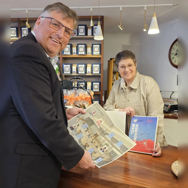 Landrat Stefan Löwl und Isabel Seeber, Vorstand Dachau Handelt, freuen sich über das neue Stickeralbum. (Foto: LRA Dachau, Sina Török)