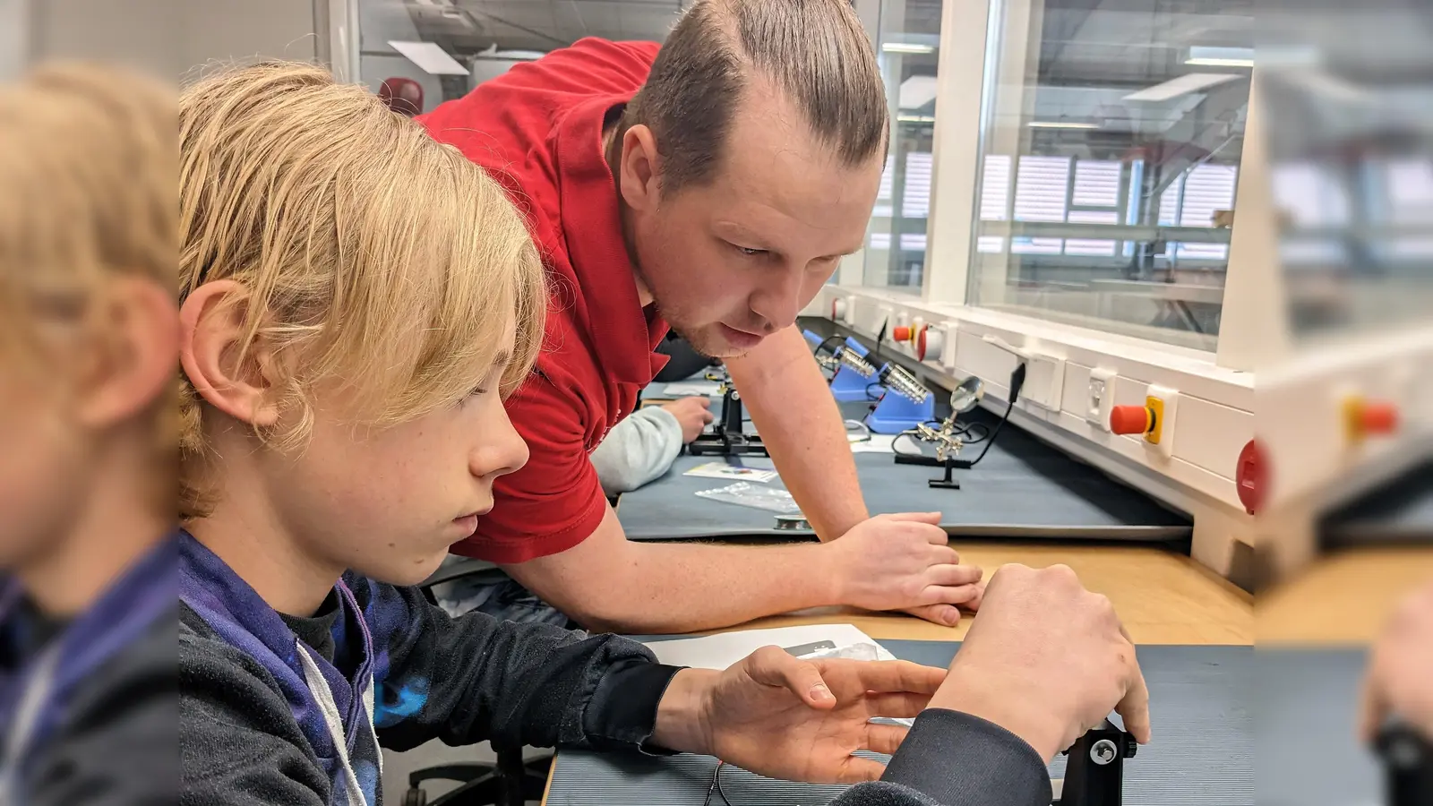 Sven Eibicht, Leitung E-Technik, mit Schüler Alexander während des Lötens an einer Platine. (Foto: Butz & Neumair GmbH Aufzugbau)