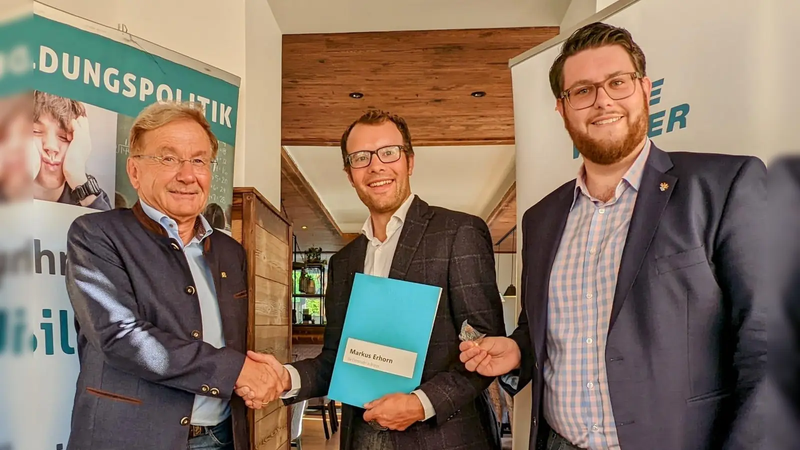 Hans Friedl (li) und Florian Lichtenstern (re) überreichen Markus Erhorn die Auszeichnung. (Foto: Freie Wähler Dachau)