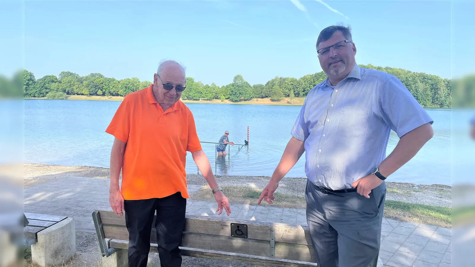 <br>Landrat Stefan Löwl und Hartmut Baumgärtner an einer der fünf Bänke, die nun per Schild Menschen mit Behinderung Vorrang gewährt. (Foto: LA Dachau / Sina Török)